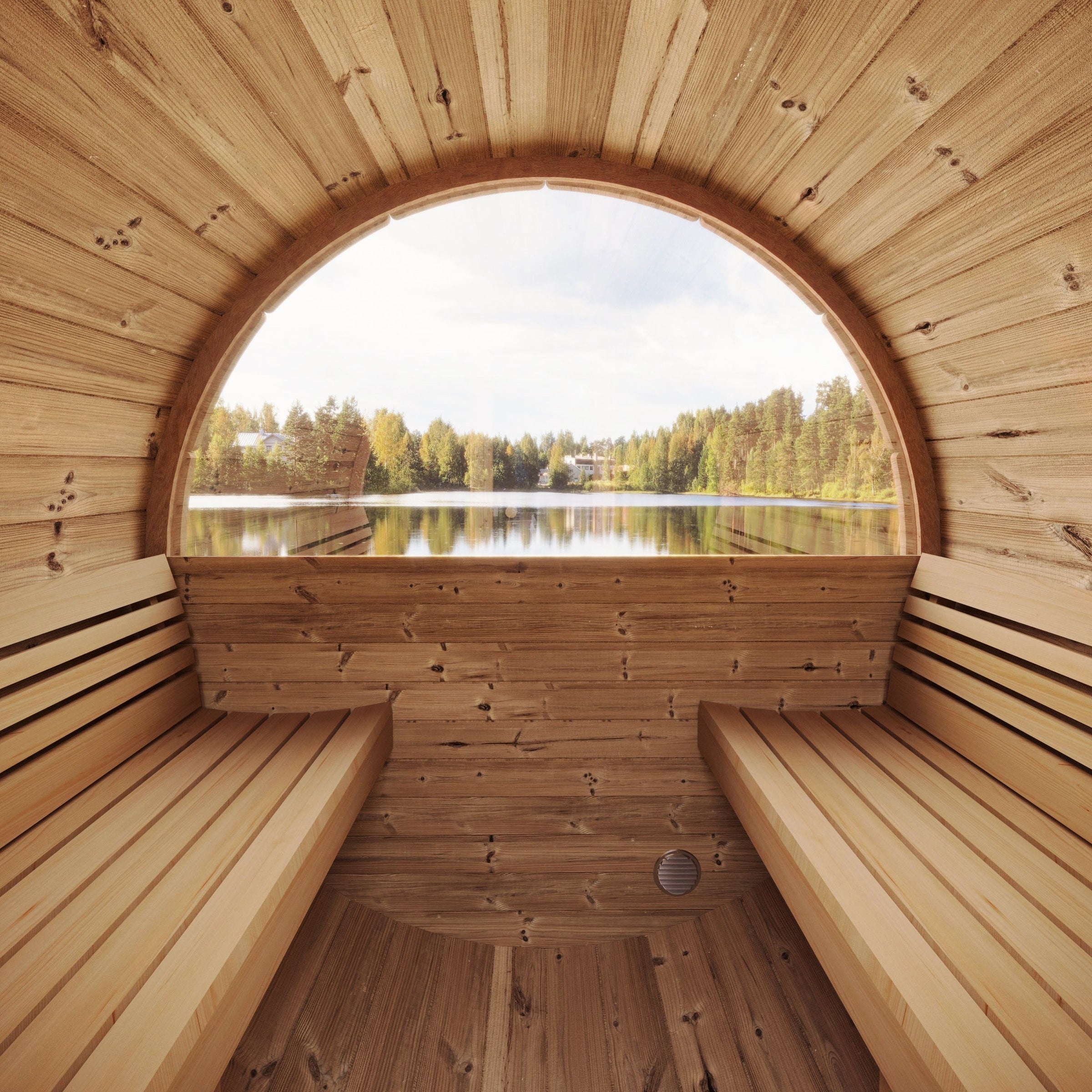 Wooden sauna with a large circular window overlooking a lake and forest.